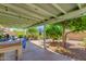 Relaxing back patio with covered patio, chairs, and blooming landscape at 6031 E Inglewood St, Mesa, AZ 85205