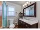 Bathroom featuring a marble countertop, wood vanity, toilet, and walk-in shower with clear glass door at 6031 E Inglewood St, Mesa, AZ 85205