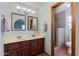 Bathroom featuring double sinks with framed mirrors, wood cabinets, and decorative tile flooring at 6031 E Inglewood St, Mesa, AZ 85205