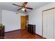 Bright bedroom featuring a ceiling fan, wood floors, and a double-door closet for storage at 6031 E Inglewood St, Mesa, AZ 85205