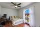 Bright bedroom featuring a ceiling fan, wood floors, a computer desk and a scenic arched window at 6031 E Inglewood St, Mesa, AZ 85205
