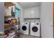 Functional laundry room with washer, dryer, and ample storage shelves at 6031 E Inglewood St, Mesa, AZ 85205