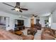 Living room features neutral paint, leather furniture, ceiling fans, and large windows at 6031 E Inglewood St, Mesa, AZ 85205