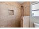 Close-up of the shower with neutral tile and a built-in niche for storage at 6031 E Inglewood St, Mesa, AZ 85205