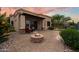 Backyard view featuring a stone firepit, paved patio area, and comfortable seating under a covered terrace at 6202 E Mckellips Rd # 65, Mesa, AZ 85215