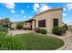 Fully landscaped backyard features a manicured lawn, mature shrubs, and a brick patio with fire pit at 6202 E Mckellips Rd # 65, Mesa, AZ 85215