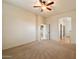 This bedroom features neutral carpet, a ceiling fan, and a view of other rooms in the house at 6202 E Mckellips Rd # 65, Mesa, AZ 85215