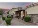 Inviting front entrance featuring stone accents, a covered porch, and lush landscaping at 6202 E Mckellips Rd # 65, Mesa, AZ 85215