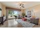 Bright living room boasting a ceiling fan, tile floors, and views of the landscaped backyard at 6202 E Mckellips Rd # 65, Mesa, AZ 85215