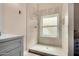 Bathroom featuring walk-in shower with white tiling, updated vanity, and window for natural light at 6416 S 19Th Pl, Phoenix, AZ 85042
