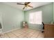 Bright bedroom with tiled floor, ceiling fan, and natural light from the large window at 6416 S 19Th Pl, Phoenix, AZ 85042