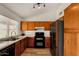 Spacious kitchen with wood cabinets, stainless refrigerator, gas range, and plenty of natural light at 6416 S 19Th Pl, Phoenix, AZ 85042