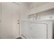 The clean laundry room features a washer and dryer with overhead shelving at 6416 S 19Th Pl, Phoenix, AZ 85042
