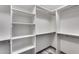 Walk-in closet with white shelving and metal rods for hanging clothes and gray wood-style flooring at 8712 W Sequoia Dr, Peoria, AZ 85382