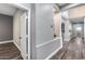 Hallway with plank flooring leading to an open concept floorplan with light gray walls at 8712 W Sequoia Dr, Peoria, AZ 85382