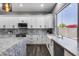 Bright kitchen features marble countertops, white cabinets, a farmhouse sink, and window view at 8712 W Sequoia Dr, Peoria, AZ 85382