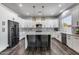 Modern kitchen with white cabinets, marble countertops, a central island, and stainless steel appliances at 8712 W Sequoia Dr, Peoria, AZ 85382