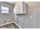 Laundry room with white cabinets above the hookups for the washer and dryer and gray walls at 8712 W Sequoia Dr, Peoria, AZ 85382