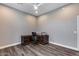 This home office features a ceiling fan and a handsome wooden desk and chair on dark wood-look floors at 8712 W Sequoia Dr, Peoria, AZ 85382