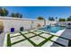 Backyard featuring a pool with a waterfall feature, travertine pavers and artificial turf at 8712 W Sequoia Dr, Peoria, AZ 85382