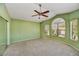 Spacious bedroom featuring neutral carpet, updated ceiling fan, and large windows at 9717 W Marco Polo Rd, Peoria, AZ 85382