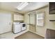 Well-lit laundry room includes a washer, dryer, and ample storage space at 9717 W Marco Polo Rd, Peoria, AZ 85382