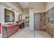 Well appointed main bathroom with dual sinks, tile floors and walls, and a luxurious walk-in shower at 9717 W Marco Polo Rd, Peoria, AZ 85382