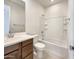 Bright bathroom featuring a tub-shower combo with a white tiled surround and neutral-toned vanity at 9845 E Tahoe Ave, Mesa, AZ 85212