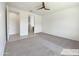This carpeted bedroom includes a ceiling fan, neutral-colored walls, and an ensuite bathroom at 9845 E Tahoe Ave, Mesa, AZ 85212