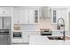 Modern white kitchen featuring stainless steel appliances, quartz countertops, and stylish backsplash at 10248 E San Salvador Dr, Scottsdale, AZ 85258