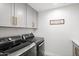 Laundry room with new gray washer and dryer units, light gray cabinets with gold handles and cute sign at 10248 E San Salvador Dr, Scottsdale, AZ 85258