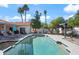 Backyard pool surrounded by lounge chairs, lush trees, and a shaded pergola with seating for outdoor relaxation at 10248 E San Salvador Dr, Scottsdale, AZ 85258