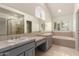 Bathroom featuring double sinks, a large mirror, separate shower, and bathtub at 10390 E Lakeview Dr # 204, Scottsdale, AZ 85258