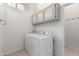 Bright laundry room featuring a washer and dryer, with overhead cabinets and a folding counter at 10390 E Lakeview Dr # 204, Scottsdale, AZ 85258