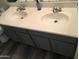 Bathroom with double sink vanity with gray cabinets, gray flooring and chrome fixtures at 10489 S 182Nd Dr, Goodyear, AZ 85338