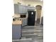Kitchen with gray cabinets, black appliances and gray plank flooring at 10489 S 182Nd Dr, Goodyear, AZ 85338
