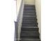 Well-lit staircase featuring neutral tones and wood-look steps at 10489 S 182Nd Dr, Goodyear, AZ 85338