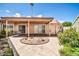 Backyard featuring a covered patio, desert landscaping elements, and concrete walkways at 10601 W Hutton Dr, Sun City, AZ 85351