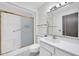 Bathroom with a shower-tub combo with sliding doors, toilet, sink, and cabinet space at 10601 W Hutton Dr, Sun City, AZ 85351