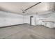 Spacious garage with a work area, white walls, concrete floors, and a utility door to the outside at 10601 W Hutton Dr, Sun City, AZ 85351