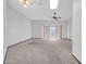 Bright living room featuring plush carpeting, ceiling fan, and sliding glass door with natural light at 10601 W Hutton Dr, Sun City, AZ 85351