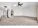 Open living room features skylight, ceiling fan, and carpet flooring with easy kitchen access at 10601 W Hutton Dr, Sun City, AZ 85351