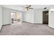 Light-filled living room with plush carpeting, ceiling fan, and sliding glass doors to outdoor patio at 10601 W Hutton Dr, Sun City, AZ 85351