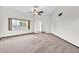 Bright living room features carpet and neutral walls with a large window and ceiling fan at 10601 W Hutton Dr, Sun City, AZ 85351