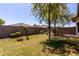 Fenced backyard with mature shade trees and garden beds, perfect for relaxation and outdoor activities at 11591 W Jefferson St, Avondale, AZ 85323