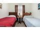 Shared bedroom featuring two twin beds with neutral walls, and carpeted floors at 11591 W Jefferson St, Avondale, AZ 85323