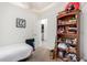 Neutral bedroom features a bed, filled bookcase, closet, and doorway that leads to a laundry room at 11591 W Jefferson St, Avondale, AZ 85323