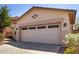 Spacious garage with a concrete driveway, featuring decorative lighting and a manicured lawn at 11591 W Jefferson St, Avondale, AZ 85323