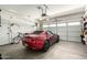 Garage with a red Mazda Miata parked inside, and a wall of windows and garage door at 11591 W Jefferson St, Avondale, AZ 85323