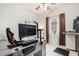 Home office with gray desk, large monitor, ceiling fan, and natural light at 11591 W Jefferson St, Avondale, AZ 85323